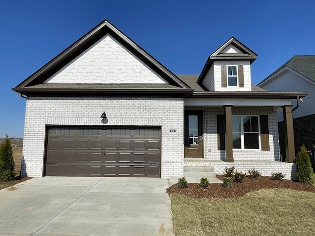 view of front of property featuring a garage, concrete driveway, and brick siding