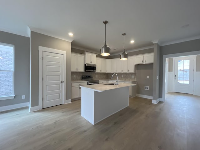 kitchen featuring ornamental molding, stainless steel appliances, tasteful backsplash, and a sink