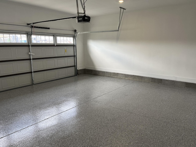 garage with baseboards and a garage door opener