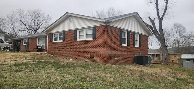 view of side of property with a yard and central air condition unit