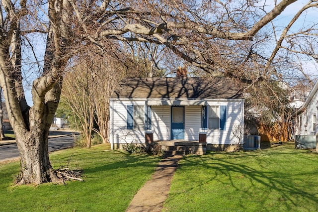 view of front of house with a front yard and central AC unit