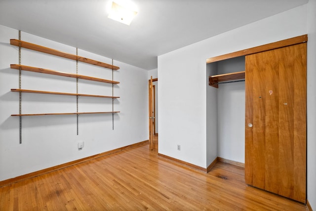 unfurnished bedroom with light hardwood / wood-style floors and a closet