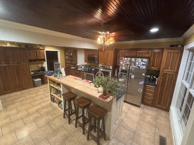 kitchen with stainless steel appliances, visible vents, a center island with sink, and crown molding