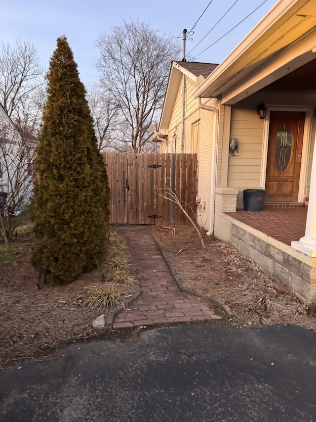 view of property exterior featuring fence and brick siding