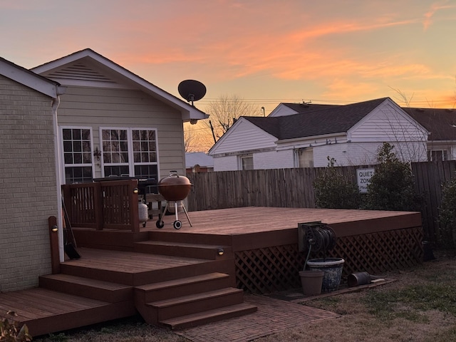 deck at dusk featuring fence