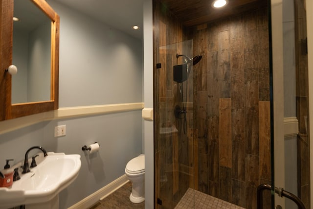 bathroom featuring baseboards, toilet, a shower stall, a sink, and recessed lighting