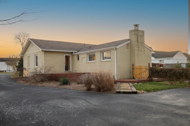 single story home featuring brick siding and a chimney