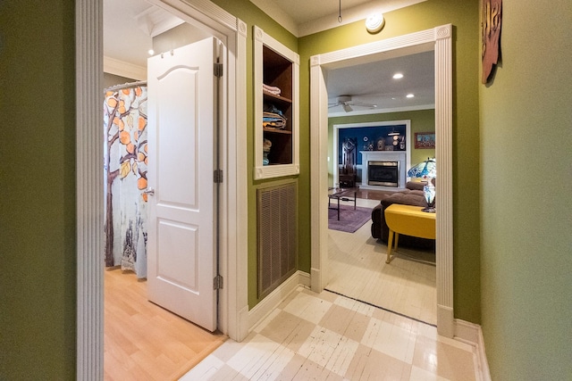 corridor with ornamental molding, light wood-type flooring, visible vents, and recessed lighting