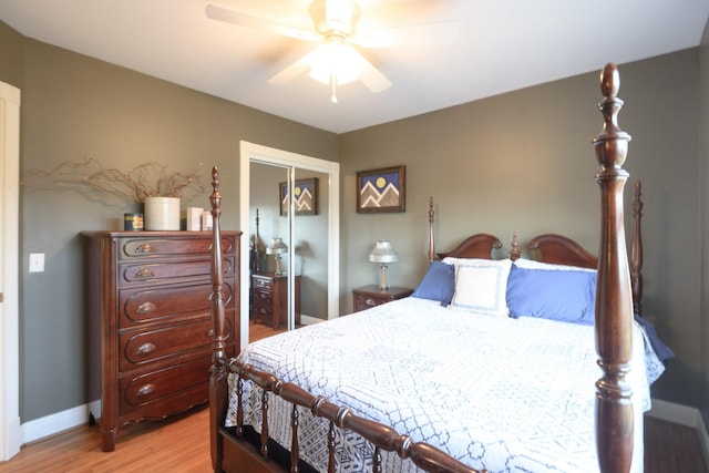 bedroom with a closet, baseboards, ceiling fan, and light wood finished floors