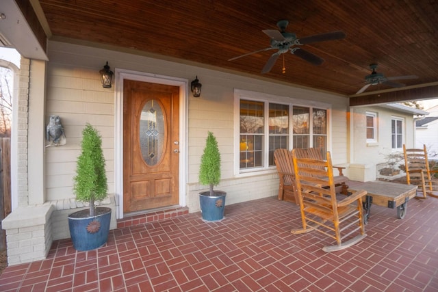 doorway to property featuring ceiling fan and brick siding