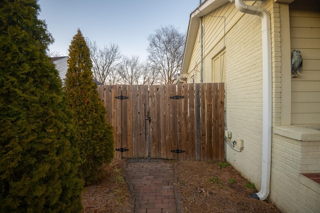 view of property exterior with fence and brick siding