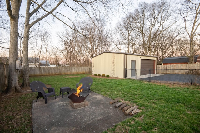 view of yard with a garage, an outdoor fire pit, an outdoor structure, and a fenced backyard