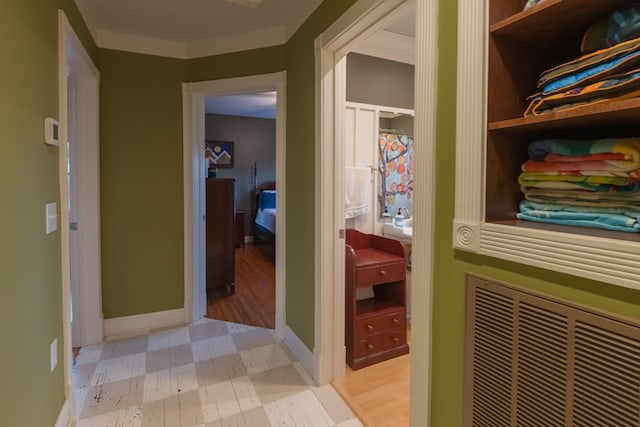 hallway featuring baseboards, visible vents, and light floors