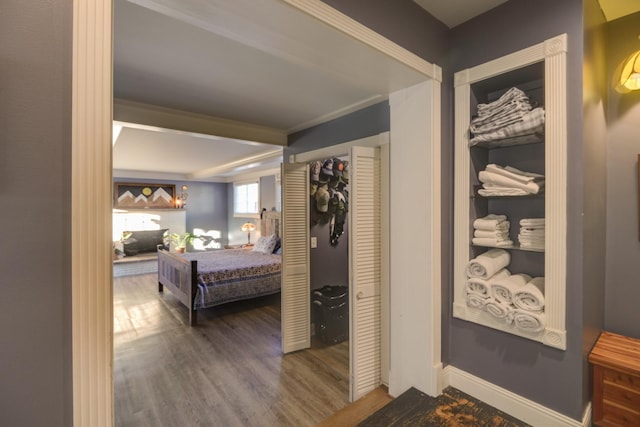 hallway featuring baseboards and wood finished floors