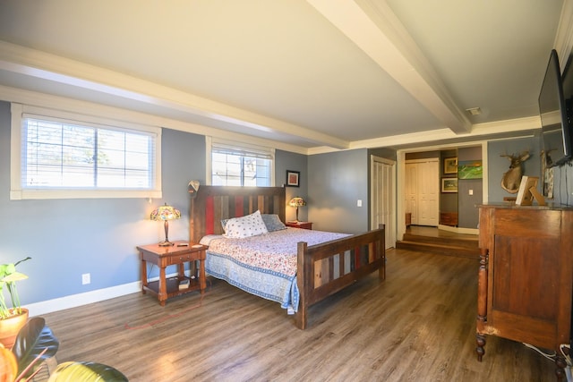 bedroom featuring beam ceiling, baseboards, and wood finished floors