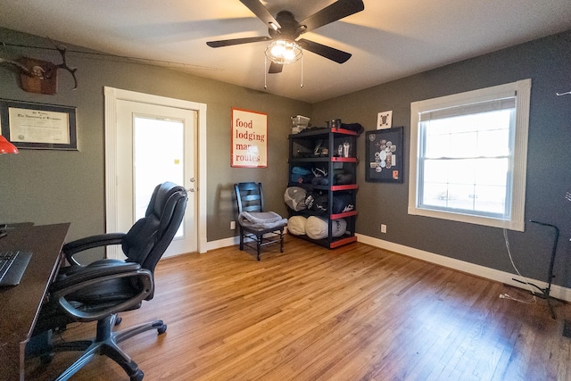 office area with wood finished floors, a ceiling fan, and baseboards