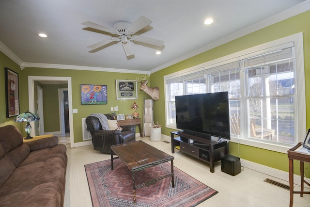 living room with a ceiling fan, visible vents, crown molding, and baseboards