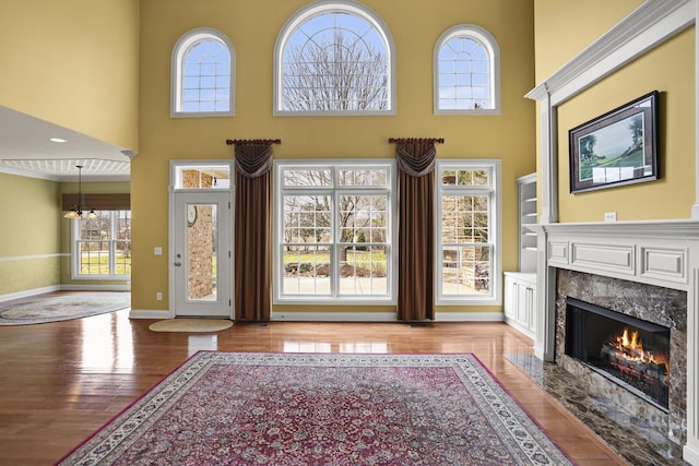 foyer with a premium fireplace, a high ceiling, and light wood-type flooring