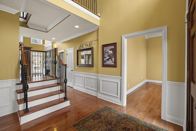 staircase with hardwood / wood-style flooring and crown molding