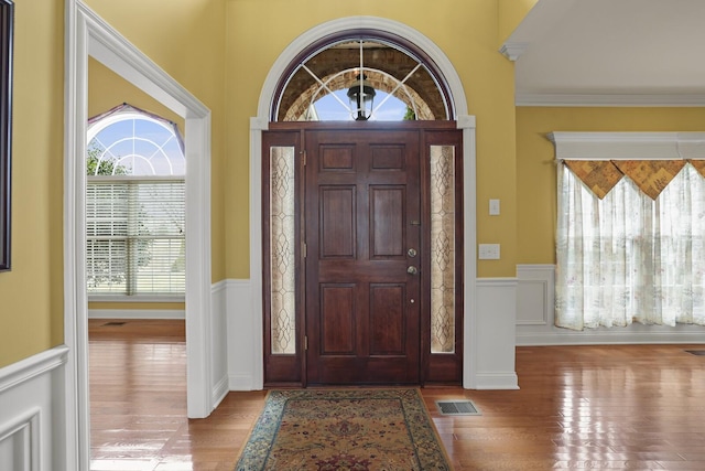 entrance foyer with ornamental molding and light wood-type flooring