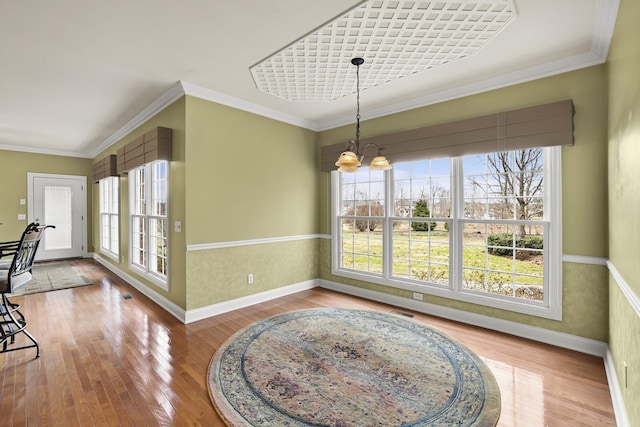 dining space featuring ornamental molding, plenty of natural light, a chandelier, and light hardwood / wood-style floors