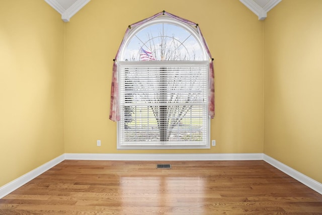 empty room featuring crown molding and hardwood / wood-style flooring