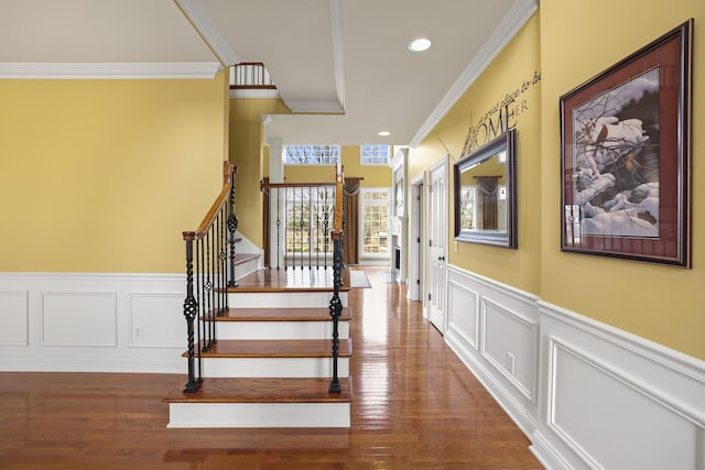 stairs with crown molding and hardwood / wood-style floors