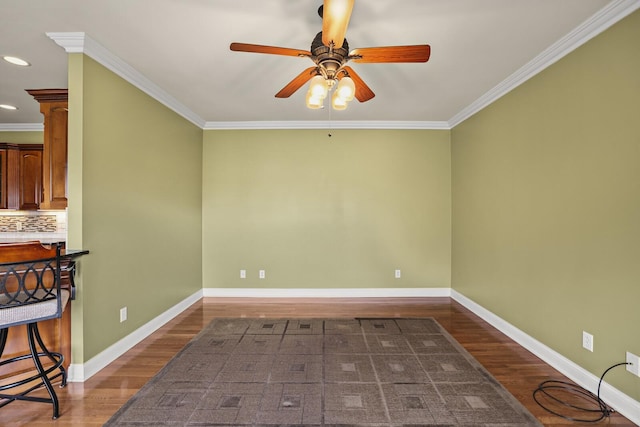 unfurnished room featuring ceiling fan, ornamental molding, and dark hardwood / wood-style flooring