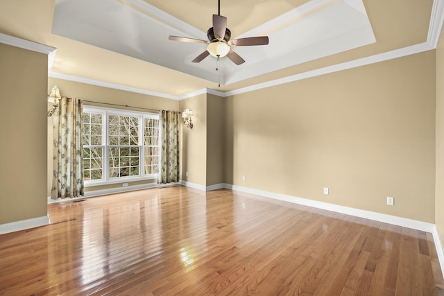 unfurnished room with hardwood / wood-style flooring, ornamental molding, ceiling fan, and a tray ceiling