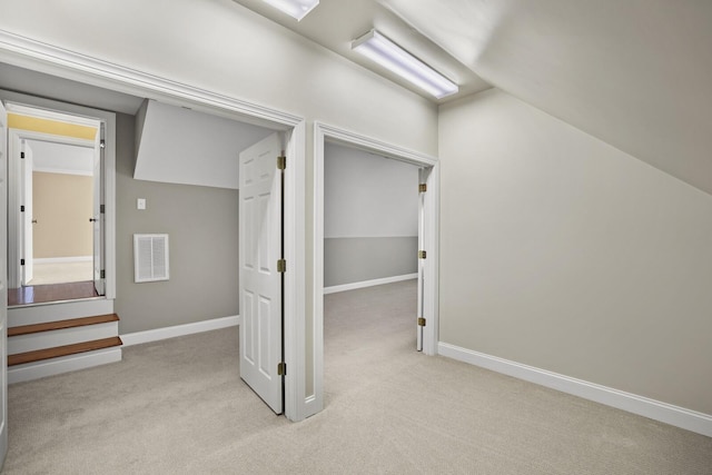 additional living space with vaulted ceiling and light carpet