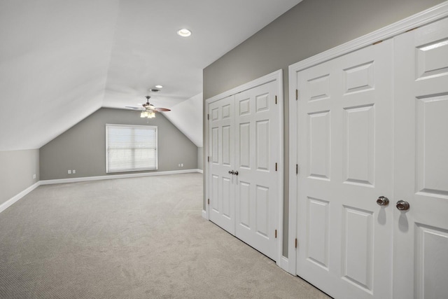 additional living space featuring vaulted ceiling, light colored carpet, and ceiling fan