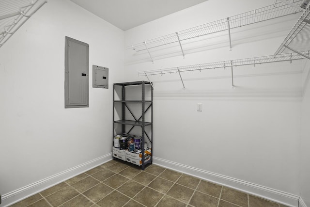 walk in closet with dark tile patterned flooring and electric panel