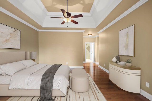 bedroom with hardwood / wood-style floors, a tray ceiling, and ornamental molding