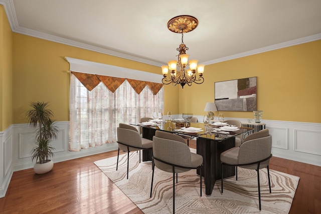 dining area featuring an inviting chandelier, crown molding, and light wood-type flooring