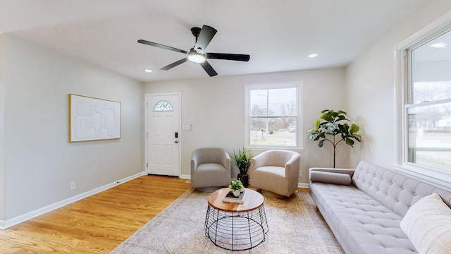 living room with light hardwood / wood-style flooring and ceiling fan