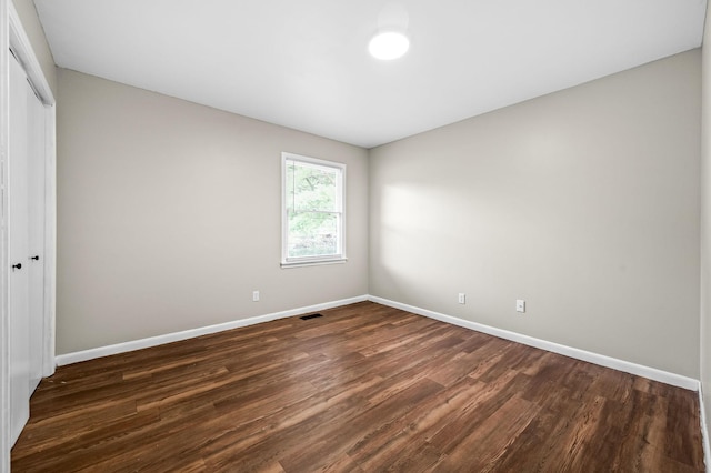 unfurnished bedroom featuring dark hardwood / wood-style floors and a closet