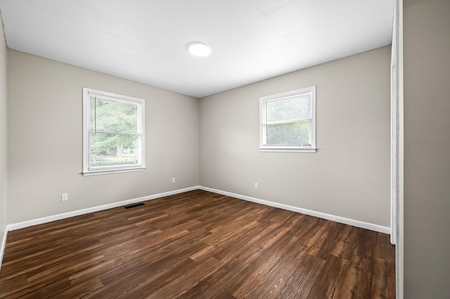 unfurnished room with a healthy amount of sunlight and dark hardwood / wood-style flooring