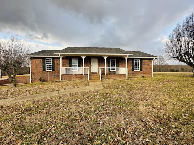 ranch-style home featuring covered porch and a front lawn