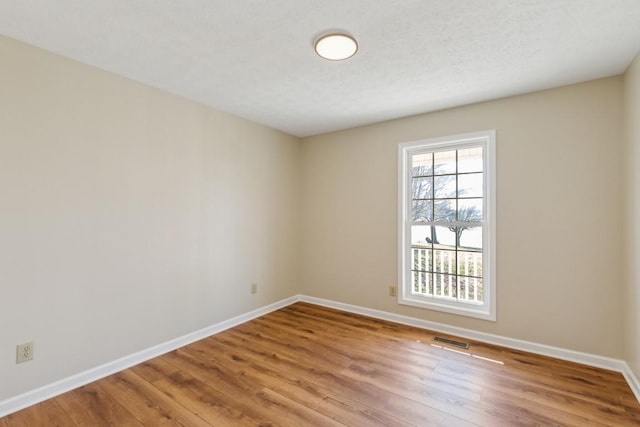 spare room with hardwood / wood-style floors and a textured ceiling