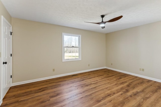 spare room featuring ceiling fan, dark hardwood / wood-style floors, and a textured ceiling