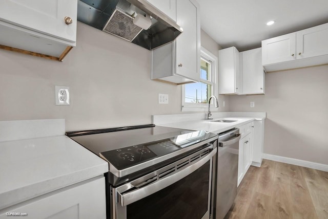 kitchen with white cabinetry, appliances with stainless steel finishes, sink, and extractor fan