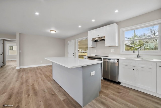 kitchen with sink, appliances with stainless steel finishes, a center island, a healthy amount of sunlight, and white cabinets