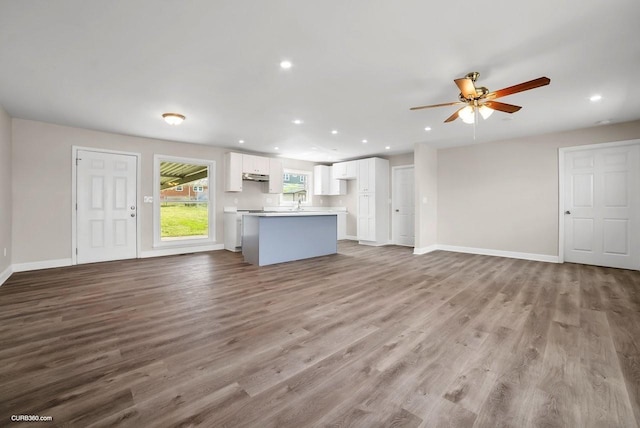 unfurnished living room with ceiling fan and light wood-type flooring