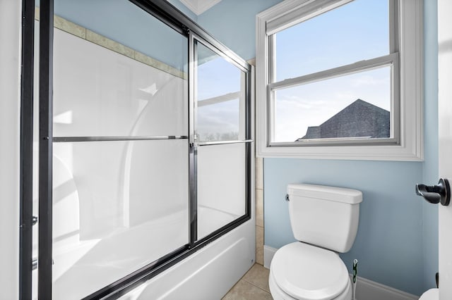 bathroom with toilet, tile patterned flooring, and combined bath / shower with glass door