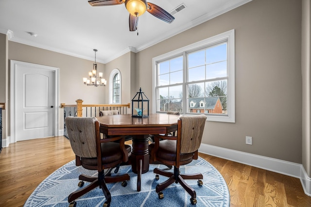 dining area with crown molding, ceiling fan with notable chandelier, and light wood-type flooring