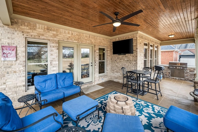 view of patio featuring a grill, ceiling fan, and exterior kitchen