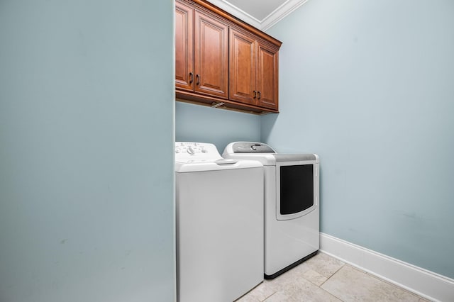 laundry room with washer and clothes dryer, ornamental molding, and cabinets