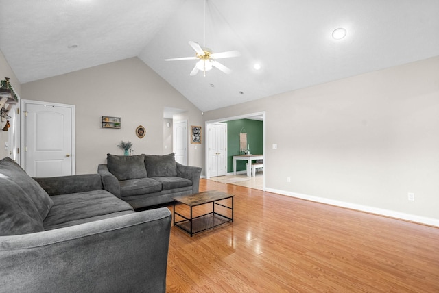 living room with ceiling fan, high vaulted ceiling, and light hardwood / wood-style floors