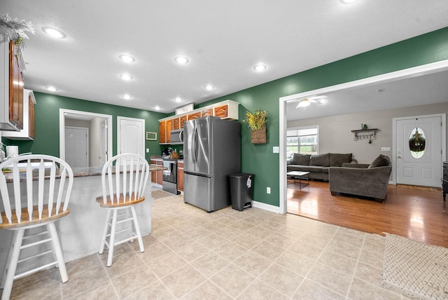 kitchen featuring light hardwood / wood-style flooring, a breakfast bar, and appliances with stainless steel finishes