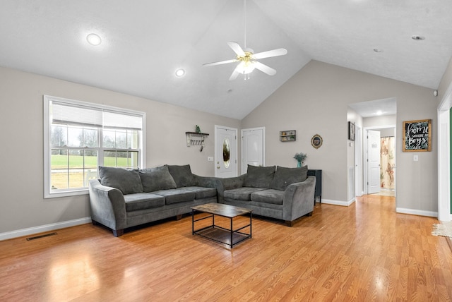 living room featuring ceiling fan, high vaulted ceiling, and light wood-type flooring